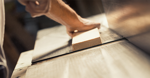 a joinery shaving off a piece of wood on his worktop 