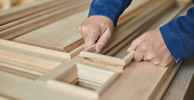 a joiner placing a sanded piece of a door into the frame to create the whole door