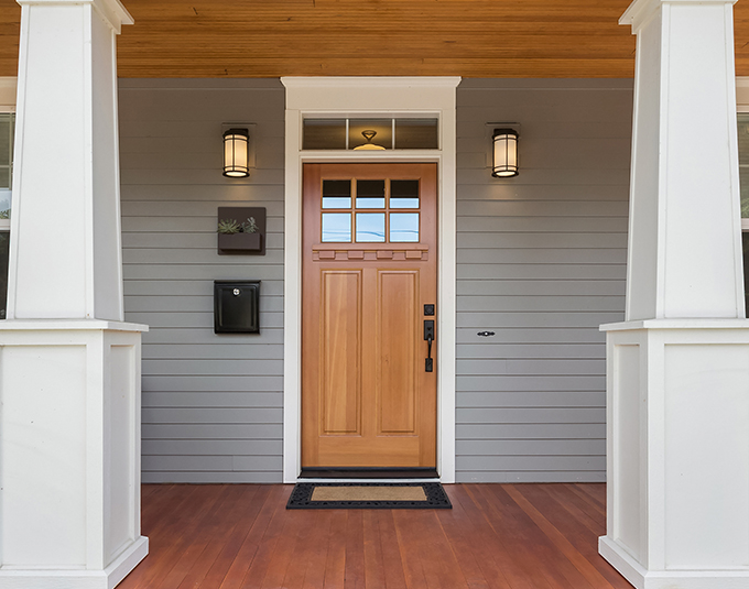 a wooden front door on a house with a porch
